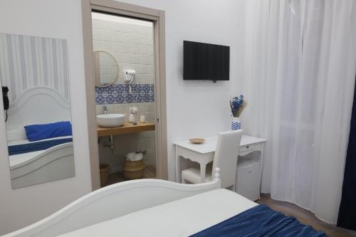 a bedroom with a bed and a desk and a mirror at B&B AnMa in Ercolano