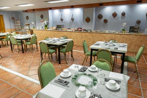 a dining room with tables and green chairs at Hotel Faranda Alisas Santander, Ascend Hotel Collection in Santander