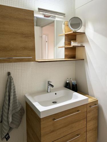 une salle de bain avec un lavabo et un miroir dans l'établissement Le Cocon d'Éragny, à Éragny