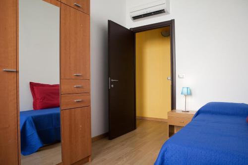 ein Schlafzimmer mit einem blauen Bett und einem Kleiderschrank in der Unterkunft Abba De Mar in Alghero