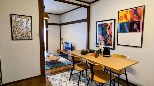 a dining room with a wooden table and chairs at Animal Art Apartment Type 22 in Ogikubo