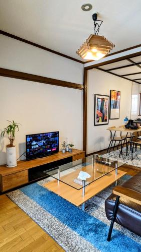 a living room with a television and a table at Animal Art Apartment Type 22 in Ogikubo