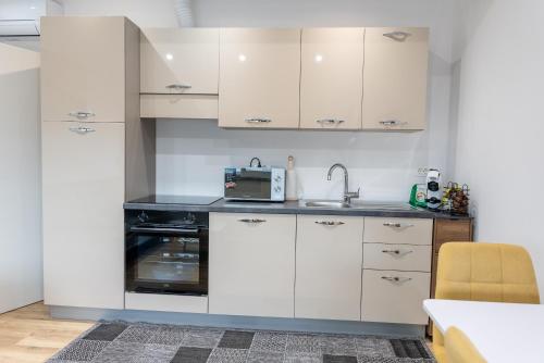 a kitchen with white cabinets and a sink at GOLDEN OASIS Free Private Parking in Ljubljana