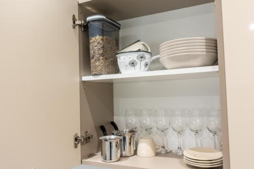 a cupboard filled with glasses and plates and dishes at GOLDEN OASIS Free Private Parking in Ljubljana