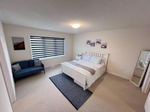a bedroom with a bed and a couch and a window at Brand New Luxurious 4B Townhouse in Oshawa