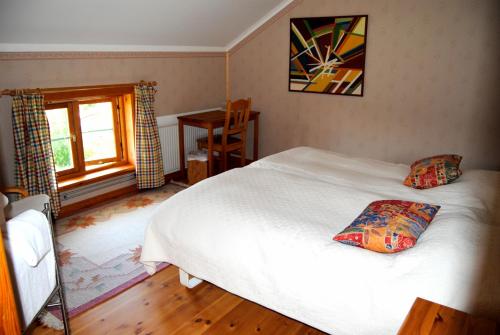 a bedroom with a white bed and a window at Tingvall B&B Eco-Lodge in Bullaren