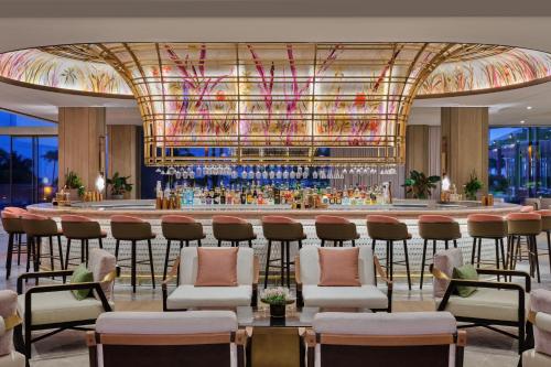a bar in a hotel lobby with a bar with stools at The St. Regis Longboat Key Resort in Longboat Key