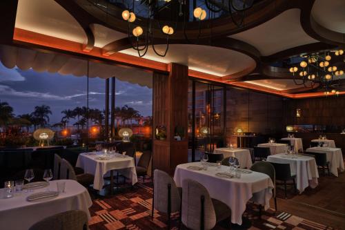 a restaurant with white tables and chairs and lights at The St. Regis Longboat Key Resort in Longboat Key