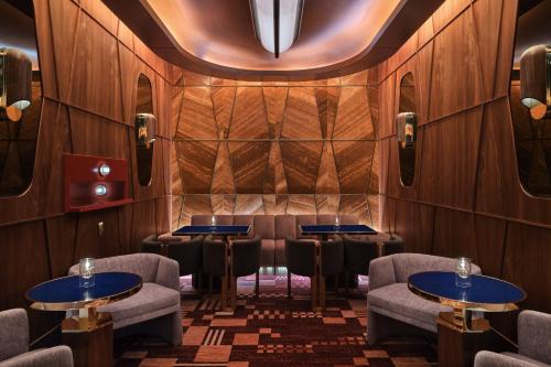 a restaurant with tables and chairs in a room with wood walls at The St. Regis Longboat Key Resort in Longboat Key