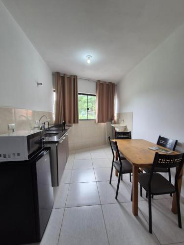 a kitchen and dining room with a table and chairs at Estúdio Charmoso no Centro de Apiaí in Apiaí