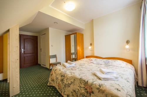 a hotel room with a bed with towels on it at Willa Excelsior in Zakopane