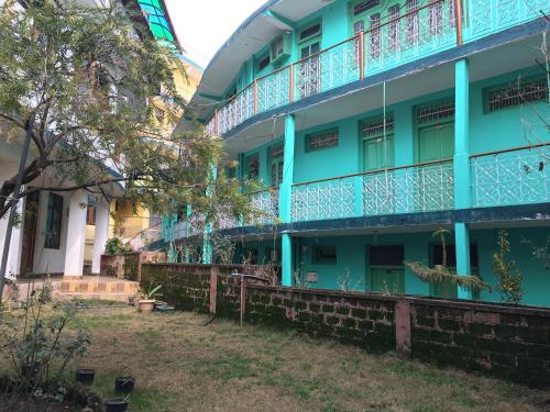 a blue building with a balcony on the side at Green Hotel in Dharamshala