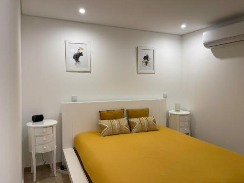 a bedroom with a yellow bed with two night stands at Casa da nascente douro in Paços de Gaiolo