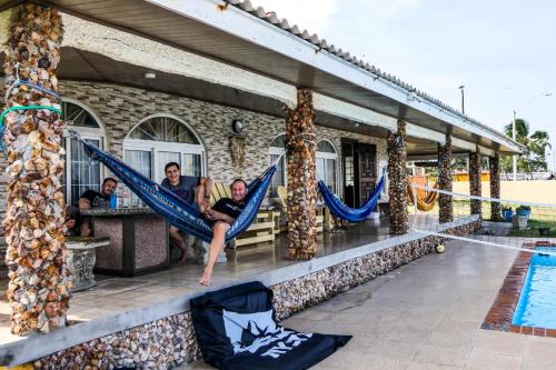 a group of people sitting in hammocks near a pool at Panama Kite House - Kite, Eat, Sleep, Repeat in Punta Chame