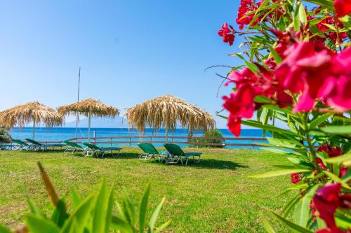 a beach with chairs and umbrellas and the ocean at Baywatch Apartments on the Beach by "elite" in Amoudi