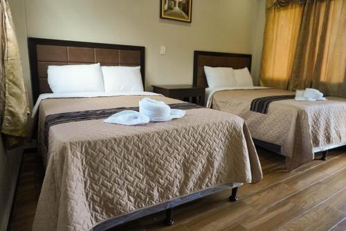 two beds in a hotel room with towels on them at Posada Rabin Ajaw in San Juan La Laguna
