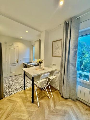une cuisine avec une table et des chaises et une fenêtre dans l'établissement Appartement Cosy proche de Disney, Paris et Charles de Gaulle, à Livry-Gargan