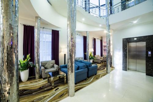 a large living room with a blue couch and chairs at Absolute Hotel in Astana