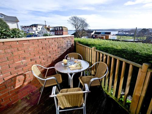 a table and two chairs sitting on a balcony at 1 Roundham Heights in Paignton