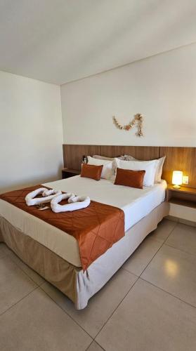 a bedroom with a large bed with towels on it at Pousada Alkamar in Maragogi