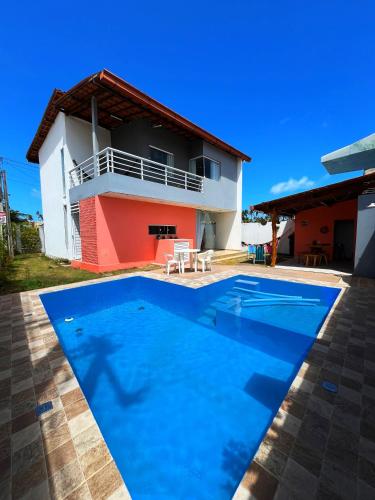 eine Villa mit einem Swimmingpool vor einem Haus in der Unterkunft Linda Casa em Praia de Gravatá in São José da Coroa Grande