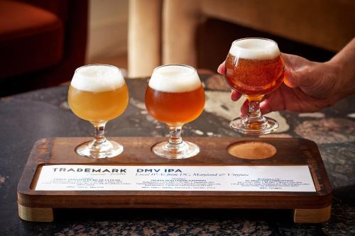 three glasses of beer on a wooden tray at The Westin Alexandria Old Town in Alexandria