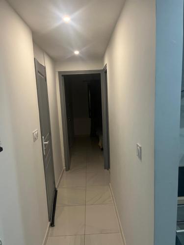 - un couloir avec deux portes et du carrelage dans l'établissement T2 dans une villa, à Bagnols-sur-Cèze