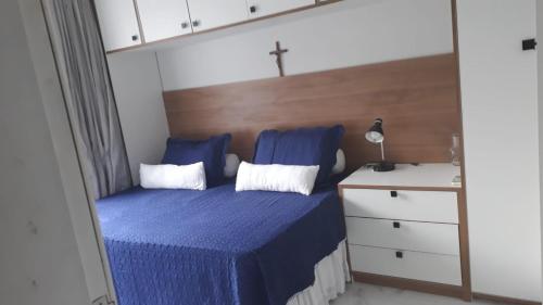 a bedroom with a blue bed with a cross on it at Itapuã Beach II Espaço climatizado com piscina privativa e área gourmet! in Salvador