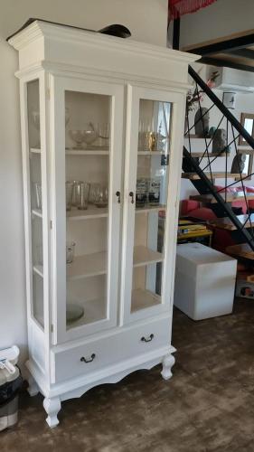 a white cabinet with glass doors in a room at Cabaña Matilda in Lago Puelo