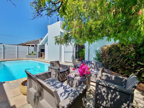 a patio with chairs and a swimming pool at Strand Boat House in Cape Town