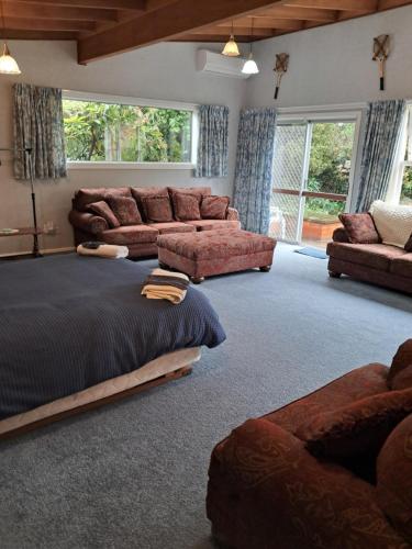 a large living room with a bed and a couch at Niloc in Waimate