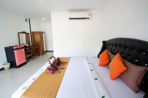 a bed in a room with orange and brown pillows at Love Seeker House in Ko Lanta