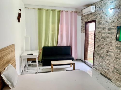 a bedroom with a bed and a chair and a desk at Maison Toutaf in Dakar