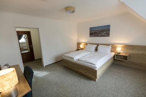 a hotel room with a bed and a desk at Cuxlandhotel Doppelzimmer 119 in Dorum Neufeld