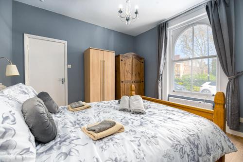 a bedroom with a bed with towels and a window at Beautiful House Refurbished in London