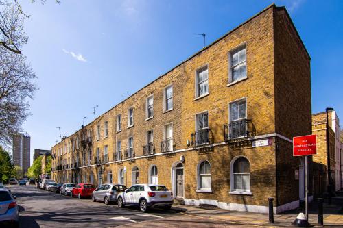 a large brick building with cars parked on a street at Beautiful House Refurbished in London