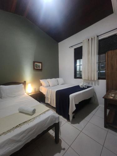 une chambre d'hôtel avec deux lits et une fenêtre dans l'établissement Casa de Praia - Ilha da Crôa - Barra de Sto Antônio, à Barra de Santo Antônio