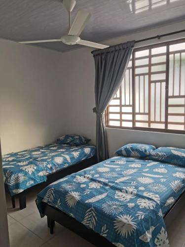a bedroom with two beds and a window at Casa Floralia in Honda