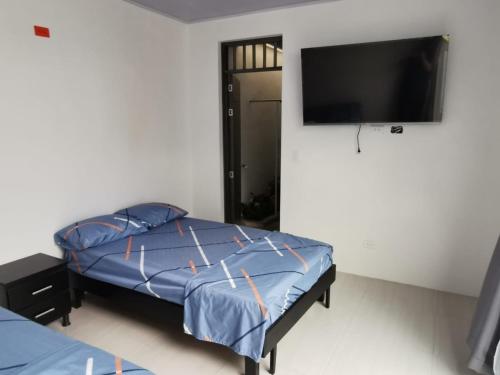 a bedroom with a bed and a flat screen tv at Casa Floralia in Honda