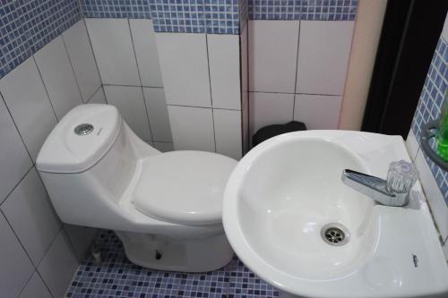a bathroom with a white toilet and a sink at Posada Rabin Ajaw in San Juan La Laguna