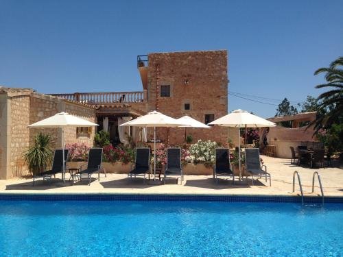a group of chairs and umbrellas next to a swimming pool at Agroturismo S Hort de Can Carrio AG226 in Ses Salines