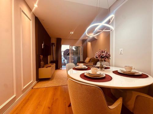 a dining room with a table and chairs at Apartamento frente Av Osvaldo Aranha Centro Canela in Canela