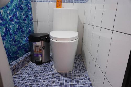 a white toilet in a bathroom with a trash can at Posada Rabin Ajaw in San Juan La Laguna