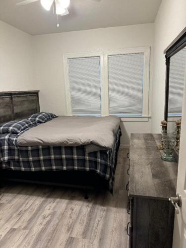 a bedroom with a bed and two windows at Bumblebee House in Oakland
