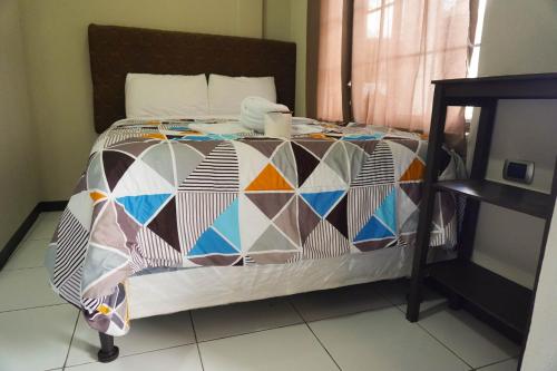 a bed with a colorful quilt on it in a room at Posada Rabin Ajaw in San Juan La Laguna