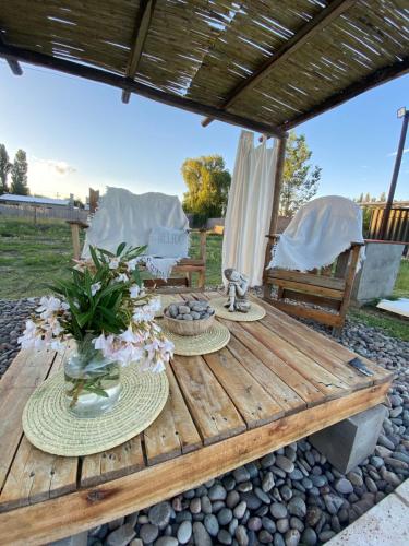a wooden table with flowers on it with two chairs at containers house in San Rafael