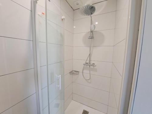 a shower with a glass door in a bathroom at Holiday Home in Brittany with Sea View in Cléder