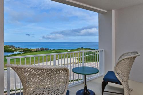 a balcony with chairs and a view of the ocean at The Residences at The St. Regis Bermuda in Saint George