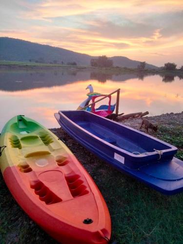 two boats sitting on the shore of a lake at ลุงไซยเดอะแคมป์ in Ban Wang Hin Ngon