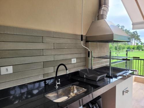 a kitchen with a sink and a counter top at Condomínio Clube lazer total na Praia da Enseada in Guarujá